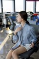 A woman sitting on a chair in an office.