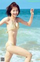 A woman in a bikini standing on the beach.