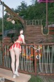 A woman in a red and white bikini standing on a bridge.