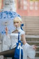 A woman in a white dress holding an umbrella.