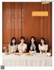 A group of women sitting at a table with plates of food.