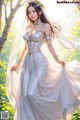 A woman in a white wedding dress standing in a forest.