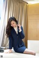 A woman in a business suit talking on a cell phone.