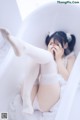 A woman laying in a bathtub with her feet up.