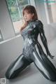 A woman in a black and silver spider suit posing for a picture.