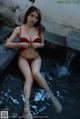 A woman in a red bikini sitting in a pool.