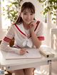 A woman sitting at a desk writing in a notebook.