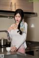 A woman standing in a kitchen holding a cup of coffee.